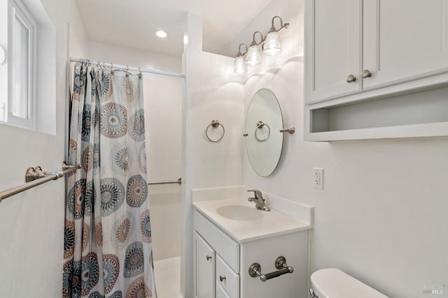 bathroom featuring a shower with curtain, vanity, and toilet