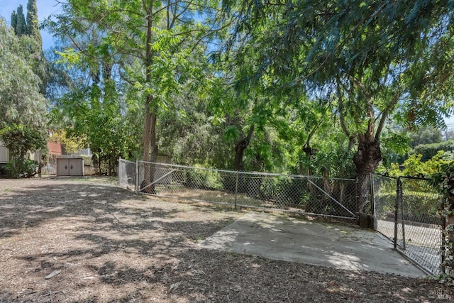 view of yard featuring fence, an outbuilding, a gate, and a shed