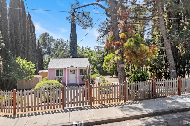 view of front of home featuring an outdoor structure and a fenced front yard