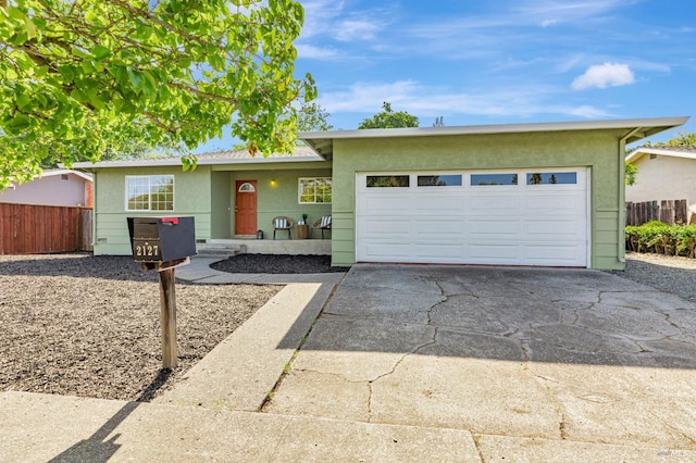 single story home featuring fence, stucco siding, an attached garage, and driveway