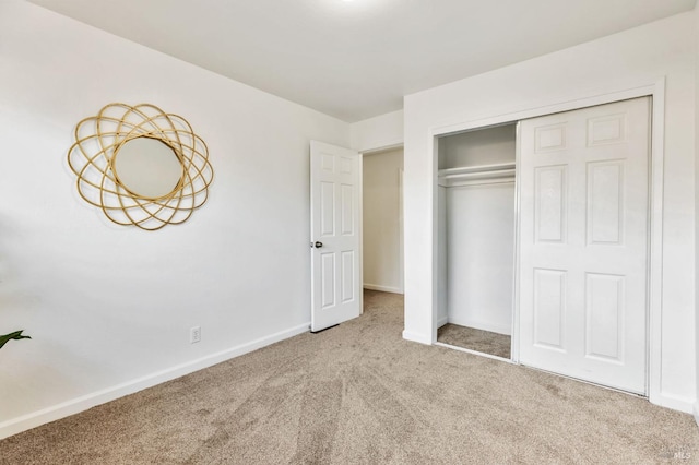 unfurnished bedroom featuring carpet floors, baseboards, and a closet