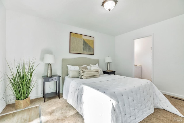 bedroom featuring baseboards, light carpet, and visible vents