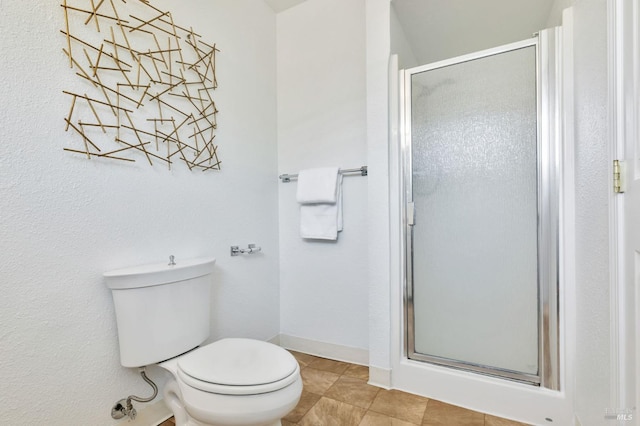 bathroom featuring baseboards, tile patterned floors, a stall shower, and toilet