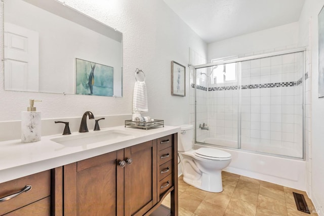 bathroom with shower / bath combination with glass door, tile patterned flooring, vanity, toilet, and visible vents