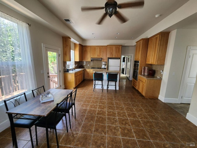 dining area with baseboards, ceiling fan, and visible vents