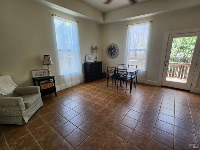 sitting room with a ceiling fan, baseboards, and a healthy amount of sunlight