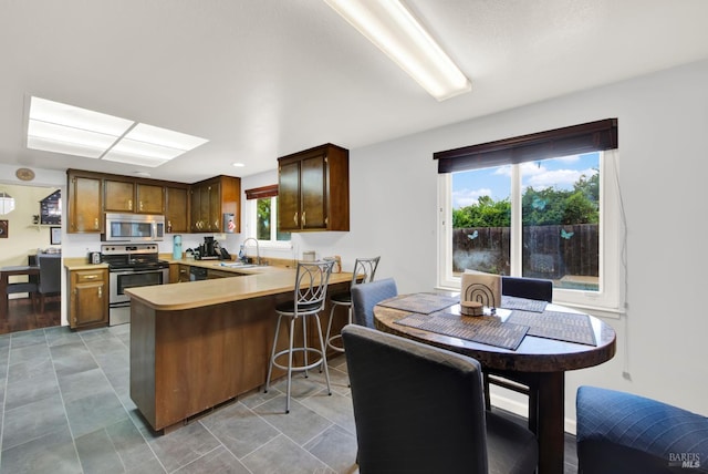954 Coventry Ln, Fairfield, CA 94533 - kitchen with stainless steel appliances, a sink, a peninsula, light countertops, and a breakfast bar