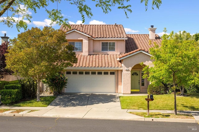 mediterranean / spanish-style house with a tiled roof, concrete driveway, a front lawn, and stucco siding