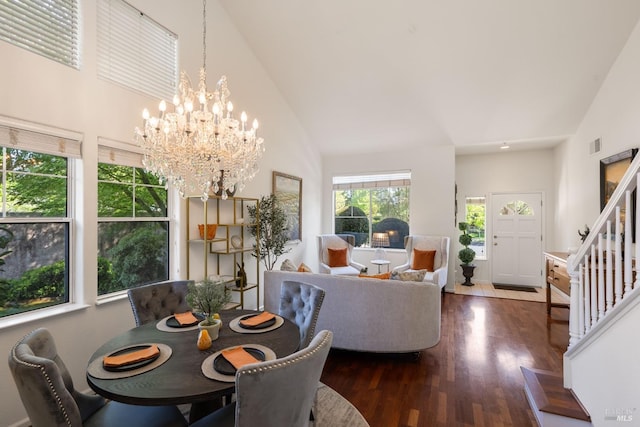 dining space featuring visible vents, an inviting chandelier, stairs, wood finished floors, and high vaulted ceiling