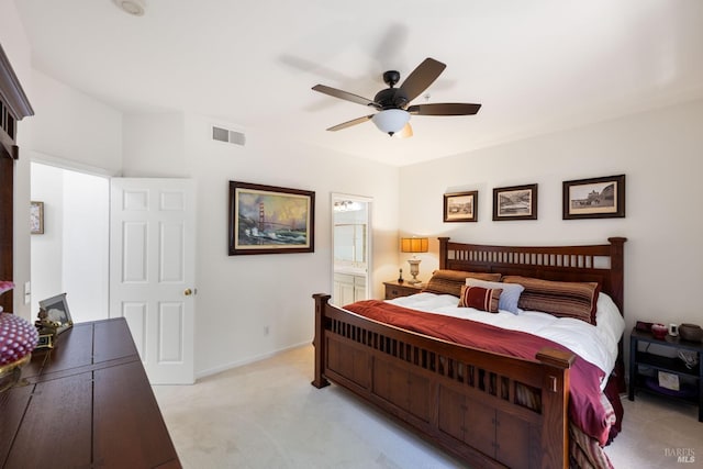 bedroom featuring visible vents, ceiling fan, ensuite bath, and light colored carpet