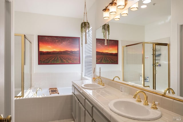 full bathroom featuring double vanity, a shower stall, a sink, and a garden tub