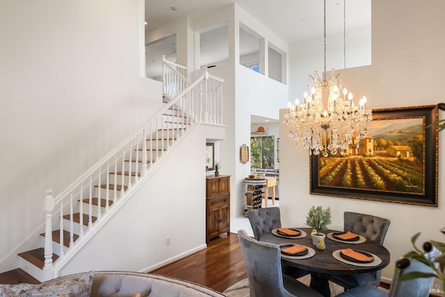 dining room featuring baseboards, wood finished floors, a chandelier, and stairway