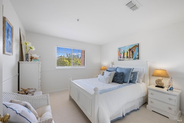 bedroom featuring baseboards, light colored carpet, and visible vents