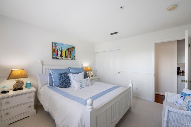 bedroom with visible vents, baseboards, carpet floors, and a closet