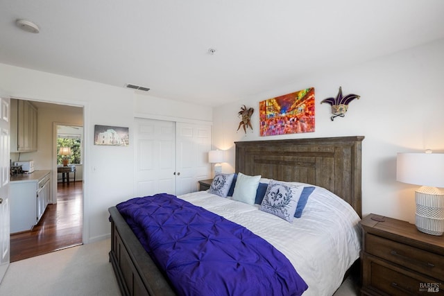 bedroom with visible vents, carpet flooring, and a closet