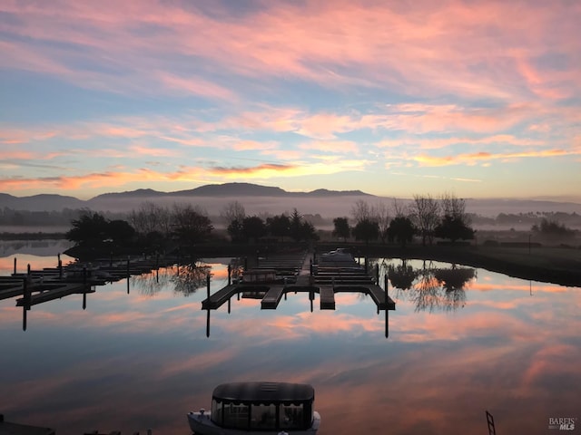 water view with a mountain view and a dock
