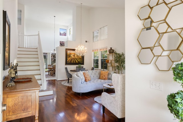 living room with an inviting chandelier, stairs, wood finished floors, and high vaulted ceiling