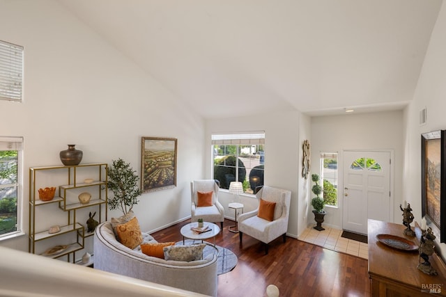 living room with high vaulted ceiling, visible vents, a healthy amount of sunlight, and wood finished floors