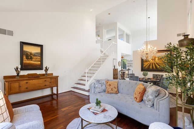 living room with visible vents, an inviting chandelier, stairway, and wood finished floors