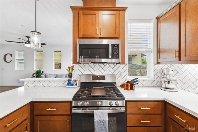 kitchen with backsplash, stainless steel appliances, brown cabinets, and light countertops