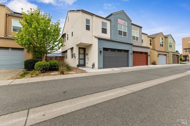 view of property with a residential view, stucco siding, and an attached garage