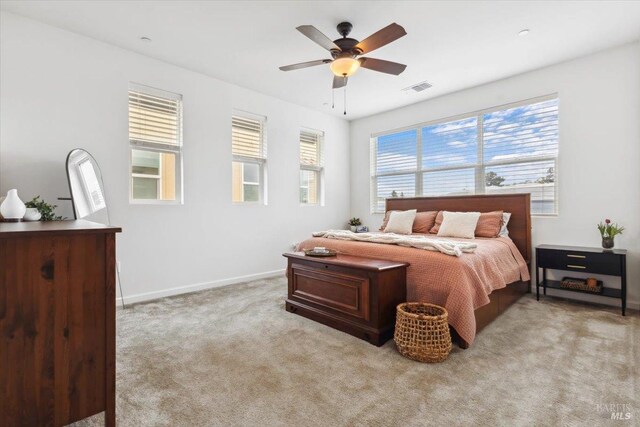 bedroom featuring light colored carpet, baseboards, visible vents, and ceiling fan