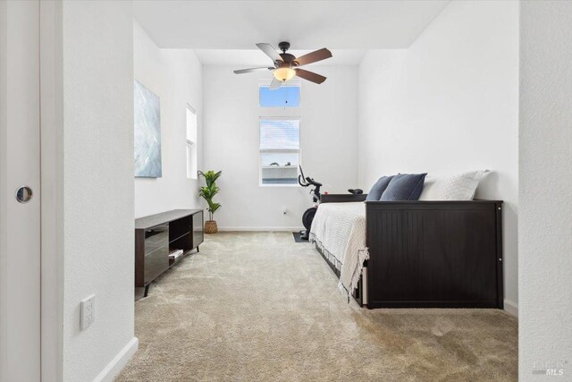 carpeted bedroom featuring baseboards and a ceiling fan