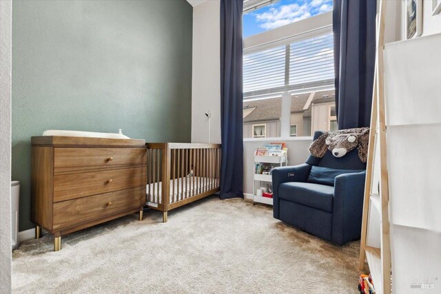 carpeted bedroom with a nursery area