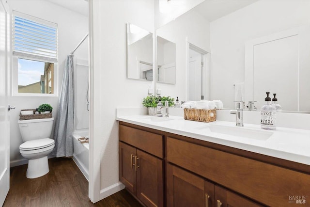 bathroom with double vanity, a sink, wood finished floors, and toilet