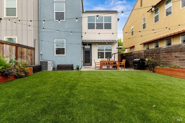 rear view of house with a patio area, central AC, a fenced backyard, a yard, and stucco siding
