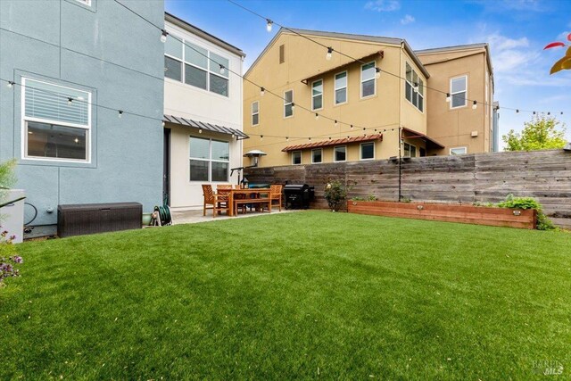 rear view of property featuring a lawn, a patio, and a fenced backyard