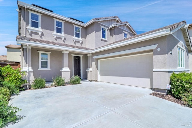 view of front facade with a garage, stucco siding, and concrete driveway