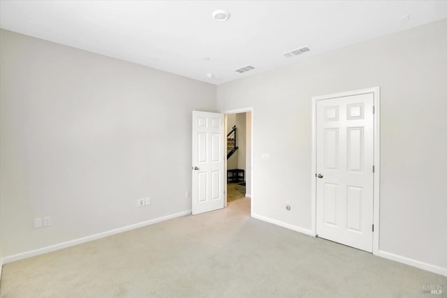 unfurnished bedroom with baseboards, visible vents, and light carpet