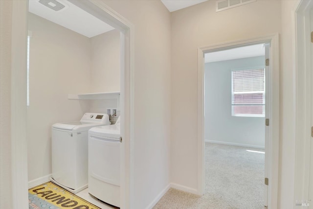 laundry area featuring laundry area, light colored carpet, baseboards, visible vents, and washer and clothes dryer