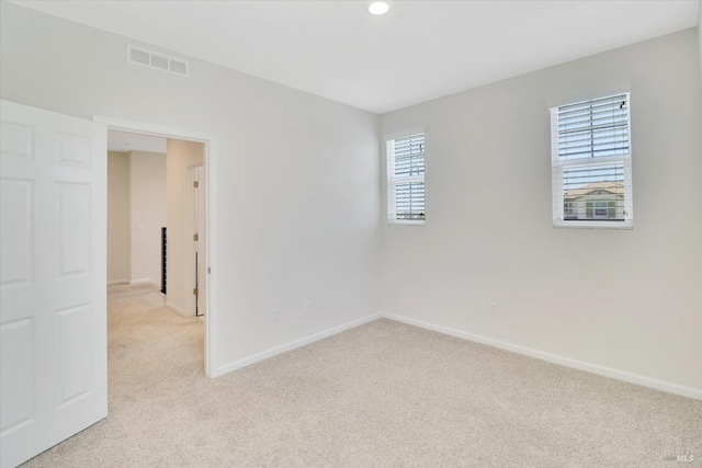 unfurnished room with recessed lighting, baseboards, visible vents, and light carpet