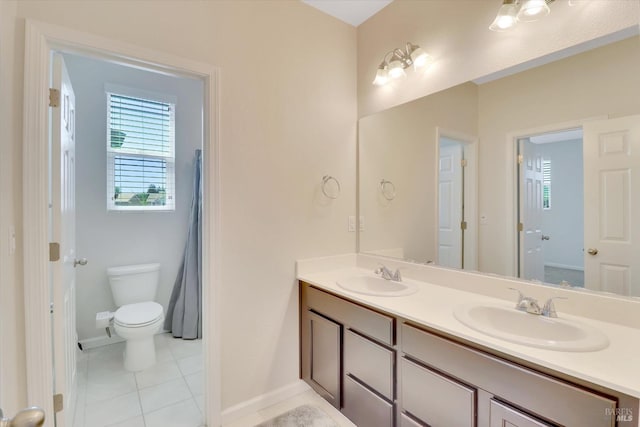 bathroom with a sink, tile patterned floors, baseboards, and double vanity