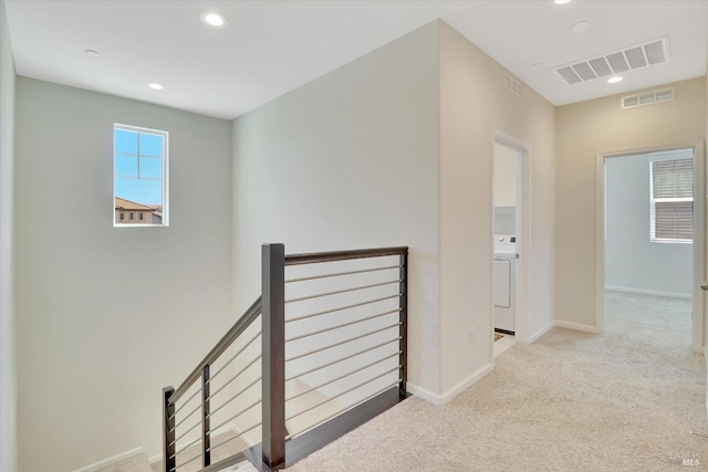 hallway featuring baseboards, an upstairs landing, carpet flooring, and visible vents