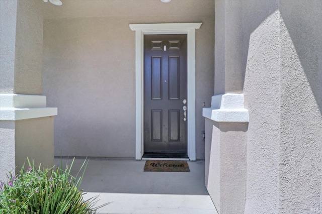 view of exterior entry with stucco siding