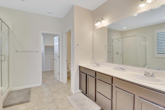 bathroom with visible vents, a sink, double vanity, and a shower stall
