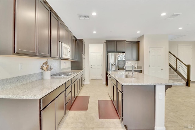 kitchen featuring a kitchen island with sink, stainless steel appliances, visible vents, and a sink