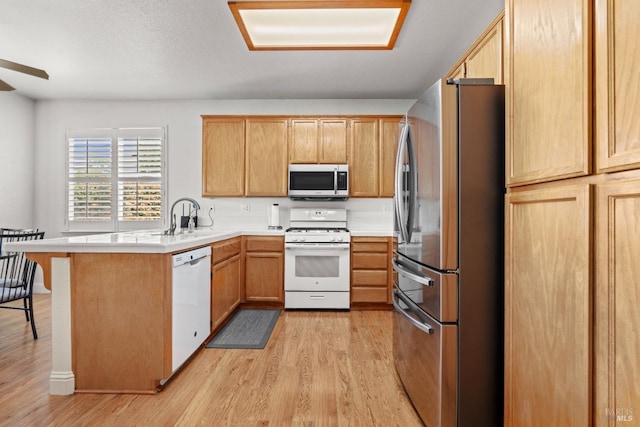 811 Inverness Dr, Rio Vista, CA 94571 - kitchen with a breakfast bar area, light wood-type flooring, a sink, a peninsula, and white appliances