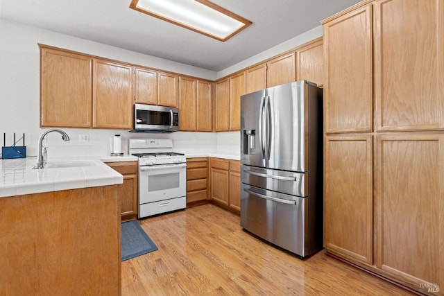 811 Inverness Dr, Rio Vista, CA 94571 - kitchen with light wood-style floors, a sink, tile counters, and stainless steel appliances