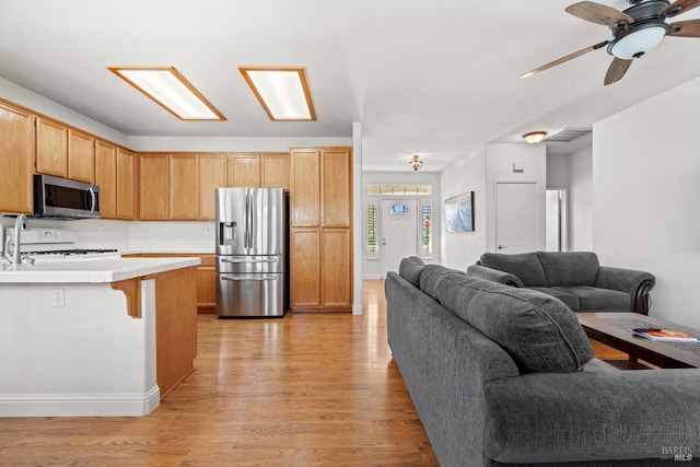 811 Inverness Dr, Rio Vista, CA 94571 - kitchen with a ceiling fan, appliances with stainless steel finishes, light countertops, light wood finished floors, and open floor plan