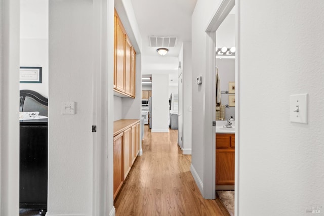 811 Inverness Dr, Rio Vista, CA 94571 - hall featuring visible vents, a sink, light wood finished floors, and baseboards