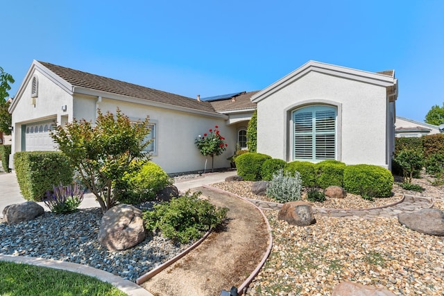 811 Inverness Dr, Rio Vista, CA 94571 - ranch-style home featuring a garage, roof mounted solar panels, and stucco siding
