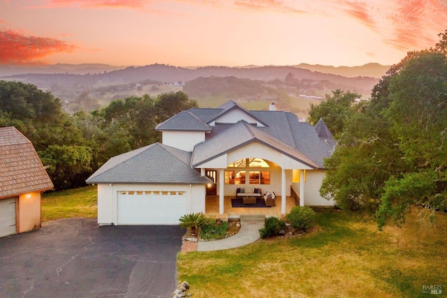 view of front of home with a lawn, outdoor lounge area, driveway, and a garage