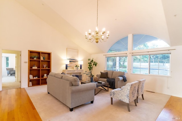 living room featuring an inviting chandelier, light wood-type flooring, and a towering ceiling