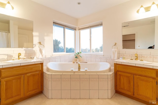 bathroom with a sink, tile patterned floors, a bath, and visible vents