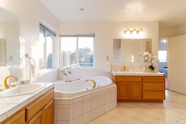 bathroom with a sink, a garden tub, and two vanities