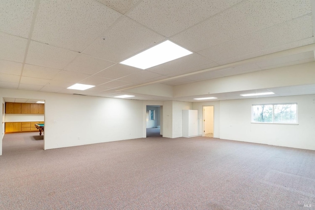 basement featuring carpet flooring and a paneled ceiling